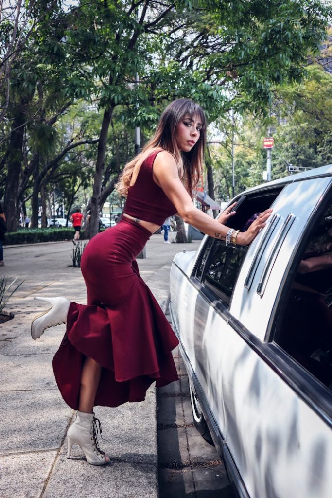 Attractive Woman in Red Dress by Limousine